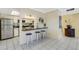 Bright kitchen with breakfast bar featuring white cabinets, stainless steel appliances, and three barstools at 200 Park N Blvd # 108, Venice, FL 34285