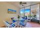 Enclosed lanai featuring tiled flooring, a round table, and four white chairs with blue cushions at 200 Park N Blvd # 108, Venice, FL 34285