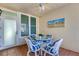 Cozy patio seating area with a glass table, wicker chairs with blue cushions, and tranquil artwork at 200 Park N Blvd # 108, Venice, FL 34285