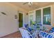 Charming patio featuring a glass-top table, wicker chairs with colorful cushions, and neutral walls at 200 Park N Blvd # 108, Venice, FL 34285