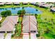 Stunning aerial view of home with tile roof, brick driveway, lush landscaping and scenic lake view at 20176 Tesoro Dr, Venice, FL 34293