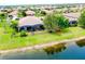 An aerial shot displays the home with its backyard, landscaping and screen enclosed patio at 20176 Tesoro Dr, Venice, FL 34293