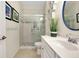 Bathroom featuring a glass shower, white vanity, and decoratively framed mirror at 20176 Tesoro Dr, Venice, FL 34293