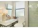 Bright bathroom vanity area with modern makeup station, chair, and convenient access to the glass-enclosed shower at 20176 Tesoro Dr, Venice, FL 34293