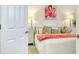 Bright bedroom featuring a white bed with decorative pillows and flamingo artwork at 20176 Tesoro Dr, Venice, FL 34293