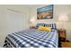 Comfortable bedroom featuring a checkered bedspread, beach-themed wall art, and stylish lamps at 20176 Tesoro Dr, Venice, FL 34293