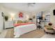Bedroom with white furnishings, ceiling fan, desk, and bright flamingo artwork at 20176 Tesoro Dr, Venice, FL 34293