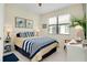 Bright bedroom with striped bedding, stylish lamps, and decorative turtle artwork at 20176 Tesoro Dr, Venice, FL 34293