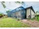 Exterior view of the screened lanai and landscaped backyard, and partial view of home at 20176 Tesoro Dr, Venice, FL 34293