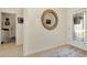 Bright foyer with tile flooring, a round mirror, and a view towards the front door at 20176 Tesoro Dr, Venice, FL 34293