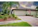 Lovely home exterior featuring a well manicured lawn, brick driveway and two car garage at 20176 Tesoro Dr, Venice, FL 34293