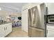 Modern kitchen featuring stainless steel refrigerator, white cabinets, and tile flooring at 20176 Tesoro Dr, Venice, FL 34293