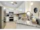 The gourmet kitchen features granite counters, stainless steel appliances, and tile backsplash at 20176 Tesoro Dr, Venice, FL 34293