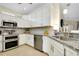The modern kitchen connects seamlessly to the dining area with stainless appliances and white cabinets at 20176 Tesoro Dr, Venice, FL 34293