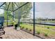 Spacious screened patio with brick flooring and furniture, offering serene views of the lake at 20176 Tesoro Dr, Venice, FL 34293