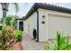 Charming home featuring a lush garden, brick walkway and a cozy, screened front door at 20176 Tesoro Dr, Venice, FL 34293