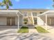 A view of the building exterior showcasing its architecture, landscaping, and covered parking with access to the units at 206 Silver Lake Dr # 105, Venice, FL 34292