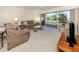 Open-concept living room featuring comfortable seating, a ceiling fan, and a sliding glass door to a screened-in lanai at 206 Silver Lake Dr # 105, Venice, FL 34292