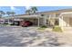 Multiple cars parked under covered parking spots outside of units in a sunny exterior shot of the condominium building at 206 Silver Lake Dr # 105, Venice, FL 34292