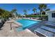 Community pool with sun loungers and umbrellas surrounded by tropical landscaping, creating a resort-like atmosphere at 206 Silver Lake Dr # 105, Venice, FL 34292