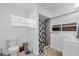 Well-lit bathroom with a tiled shower, toilet, and window with blinds for privacy at 2211 Englewood Rd, Englewood, FL 34223