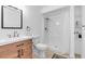 Updated bathroom with wood vanity, modern faucet, and shower with white tiled walls at 2211 Englewood Rd, Englewood, FL 34223