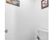 Cozy half-bathroom with a white toilet and minimal decor; simple and functional at 2211 Englewood Rd, Englewood, FL 34223