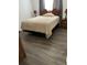 A bedroom featuring wood-look vinyl floors, a bed with a tan comforter, nightstands, and lamps at 2211 Englewood Rd, Englewood, FL 34223