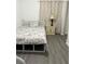 A cozy bedroom with a twin bed featuring a patterned comforter, neutral wall color, and vinyl flooring at 2211 Englewood Rd, Englewood, FL 34223