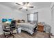 Neutral bedroom featuring a ceiling fan, desk, and striped bedding complemented by wood-look laminate flooring at 2211 Englewood Rd, Englewood, FL 34223