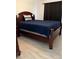A bedroom featuring a dark wooden bed frame with a blue comforter and plank flooring at 2211 Englewood Rd, Englewood, FL 34223