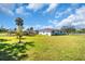 Side yard view with a well-maintained lawn and a glimpse of a single-story home at 2211 Englewood Rd, Englewood, FL 34223