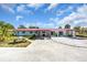 Charming single-story home featuring a unique red roof, a spacious driveway, and welcoming curb appeal at 2211 Englewood Rd, Englewood, FL 34223