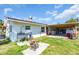 Exterior view of a home featuring an outdoor sink, a covered patio, and a serene backyard setting at 2211 Englewood Rd, Englewood, FL 34223