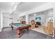 Spacious game room with a classic pool table, opening into a comfortable living area with tile floors at 2211 Englewood Rd, Englewood, FL 34223