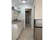 Cozy kitchenette featuring white cabinetry, laminate countertops, a mini-fridge, and light-toned tile flooring at 2211 Englewood Rd, Englewood, FL 34223
