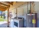 Outdoor laundry area with a washer, dryer, water heater, and access to a small yard at 2211 Englewood Rd, Englewood, FL 34223