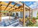Outdoor patio area featuring a wooden pergola, potted plants, and a cozy seating area at 2211 Englewood Rd, Englewood, FL 34223