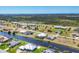 Wide aerial view showcases homes along a canal, surrounded by lush greenery and the ocean in the distance at 226 W Pine Valley Ln, Rotonda West, FL 33947