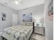 Cozy bedroom featuring a comfortable bed, soft lighting, beach-themed artwork, and serene atmosphere at 226 W Pine Valley Ln, Rotonda West, FL 33947
