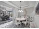 Bright dining area with stylish lighting fixture and sliding glass doors opening to the outdoor kitchen at 226 W Pine Valley Ln, Rotonda West, FL 33947