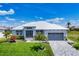 Beautiful single-story home featuring lush landscaping, a gray garage door, and a pristine white exterior at 226 W Pine Valley Ln, Rotonda West, FL 33947