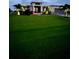 Wide shot of a well-maintained home with lush green lawn and modern design at dusk at 226 W Pine Valley Ln, Rotonda West, FL 33947
