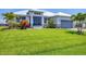 Expansive green lawn complements this single-story home with meticulous landscaping, palms, and a gray brick driveway at 226 W Pine Valley Ln, Rotonda West, FL 33947
