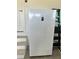 Midea white standup freezer situated on garage floor by steps, next to a ladder at 226 W Pine Valley Ln, Rotonda West, FL 33947
