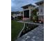 Exterior view of a home with manicured landscaping, an illuminated walkway, and decorative lighting at 226 W Pine Valley Ln, Rotonda West, FL 33947