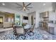 Covered patio features an outdoor kitchen, ceiling fan, TV and dining table with seating for four at 226 W Pine Valley Ln, Rotonda West, FL 33947