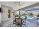 Inviting outdoor dining area with a covered patio, pool view, and a built-in kitchen at 226 W Pine Valley Ln, Rotonda West, FL 33947