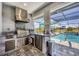 This outdoor kitchen features stainless steel appliances, countertop, sink, and views of the pool at 226 W Pine Valley Ln, Rotonda West, FL 33947