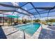 Screened-in pool with lounge chairs and umbrellas, perfect for enjoying sunny days in privacy at 226 W Pine Valley Ln, Rotonda West, FL 33947
